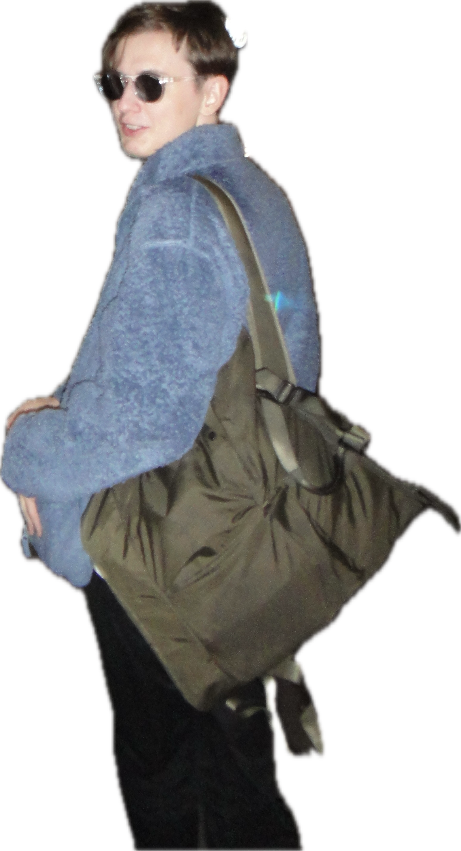 Ilia, in sunglasses and a blue fleece, with a large shoulder bag